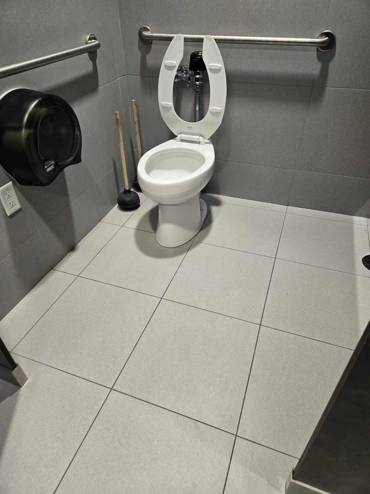A bathroom with a toilet and a paper towel dispenser.