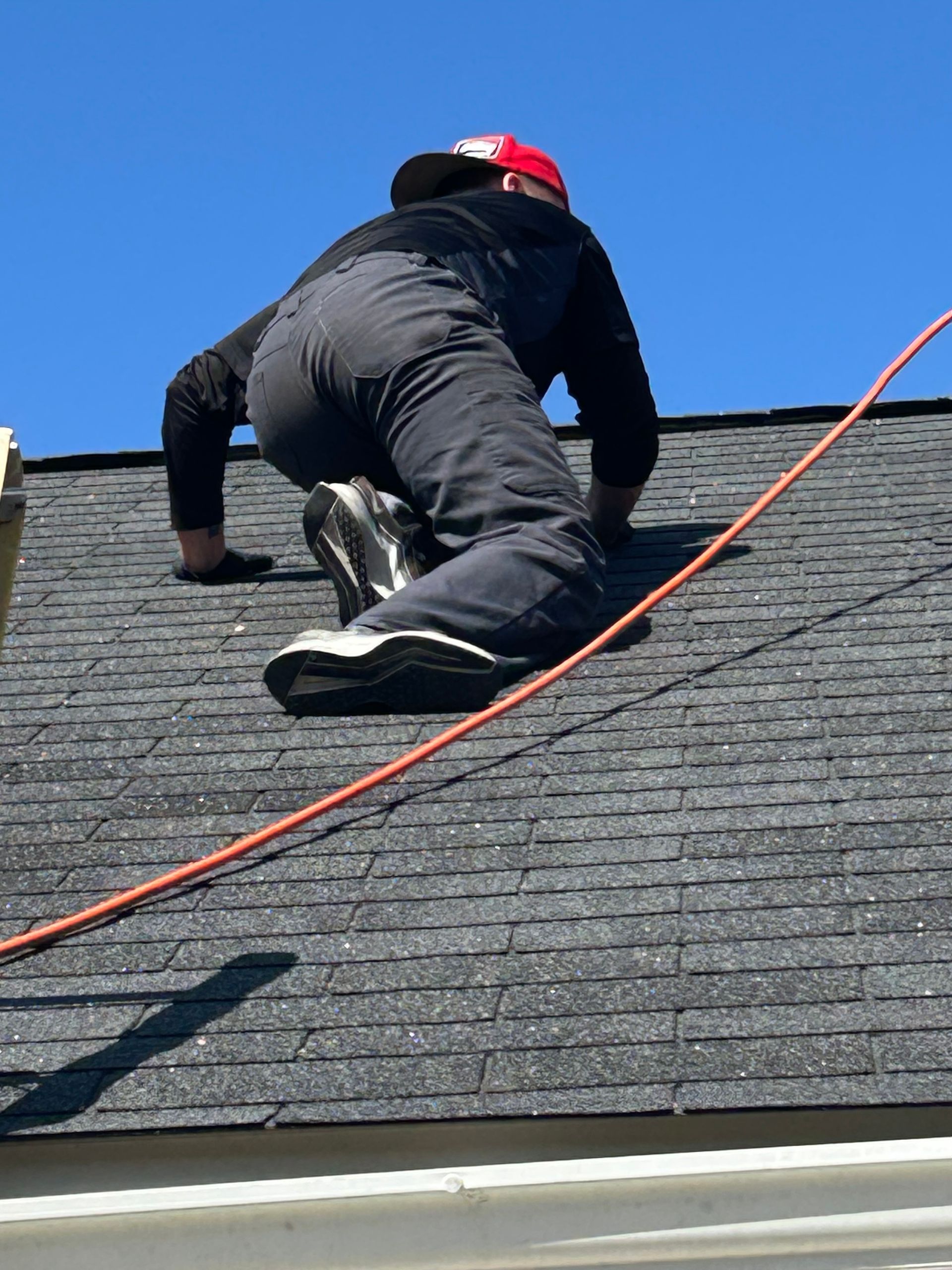 A man is working on the roof of a house