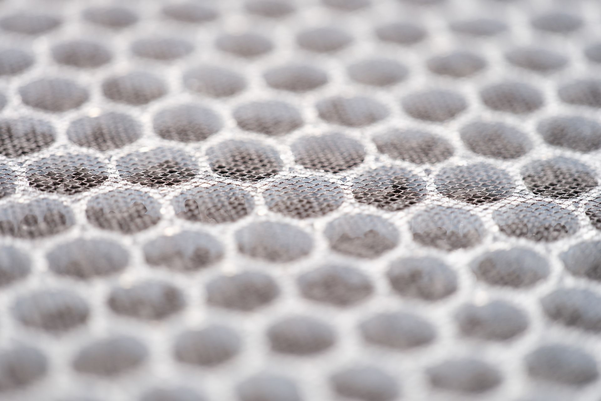 Close-up of a white and gray honeycomb-patterned mesh fabric