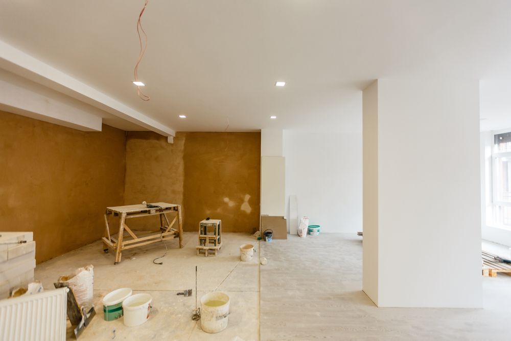 An Empty Room With a Wooden Table and Buckets of Paint — Young Building In Forster, NSW
