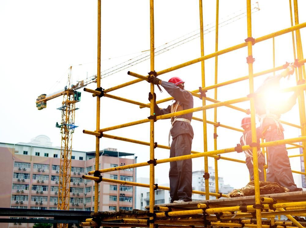 A Group of Construction Workers Are Working on a Scaffolding — Young Building In Diamond Beach, NSW