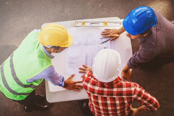 A Group of Construction Workers Are Looking at a Blueprint — Young Building In Pampoolah, NSW
