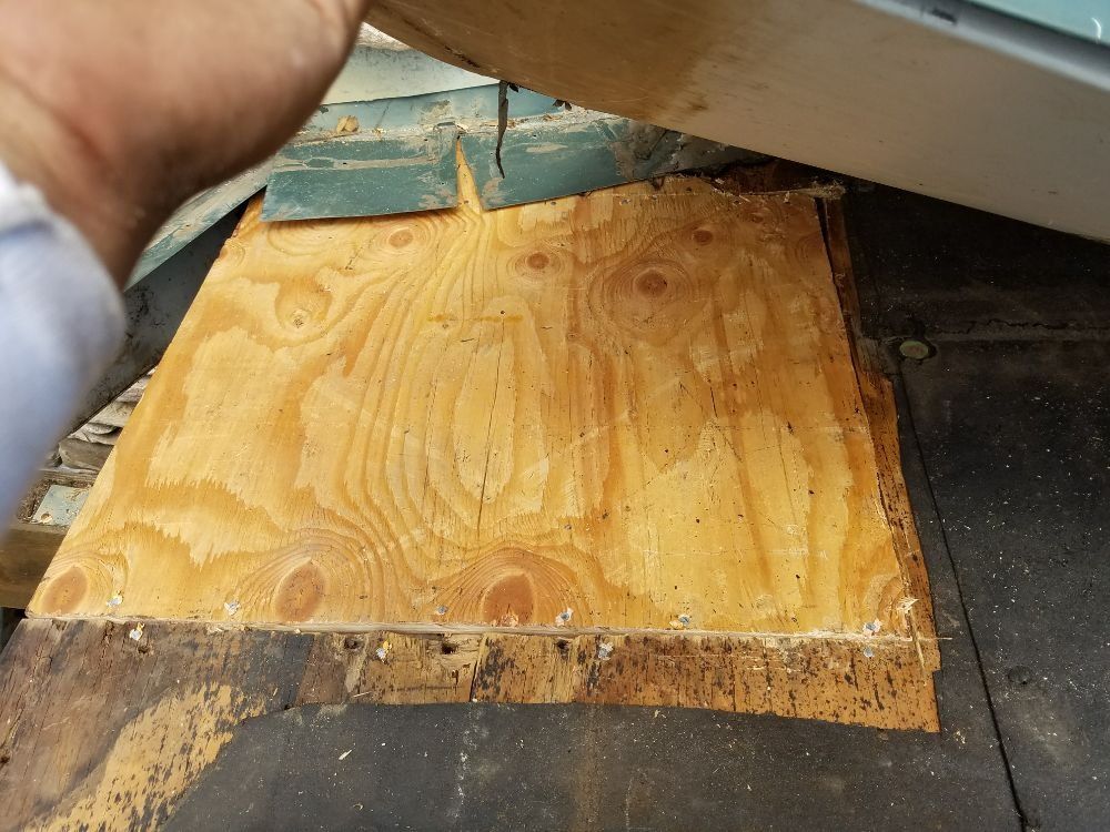 A person is cutting a piece of wood with a band saw