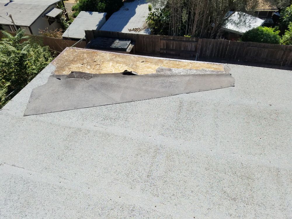 An aerial view of a roof with a fence in the background