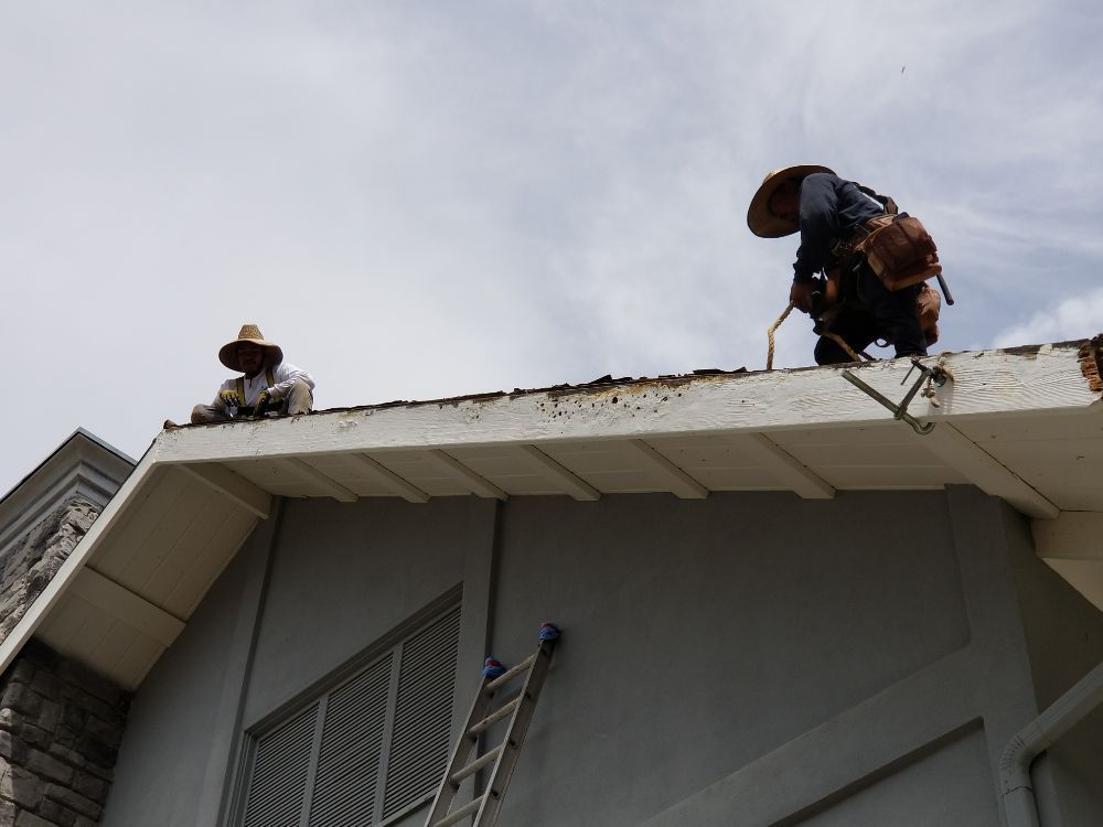 Two men are working on the roof of a building