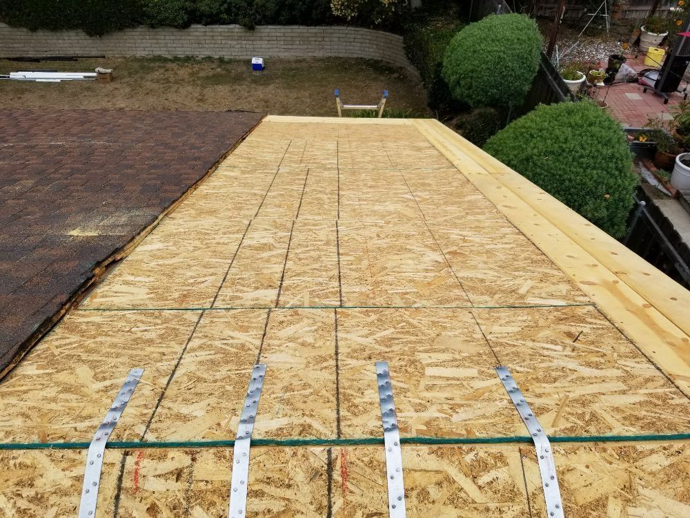A wooden roof with a ladder in the background