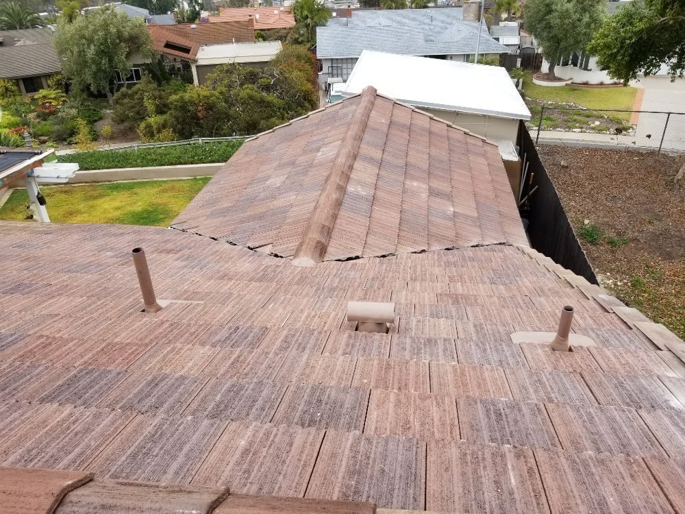 The roof of a house has a few chimneys on it