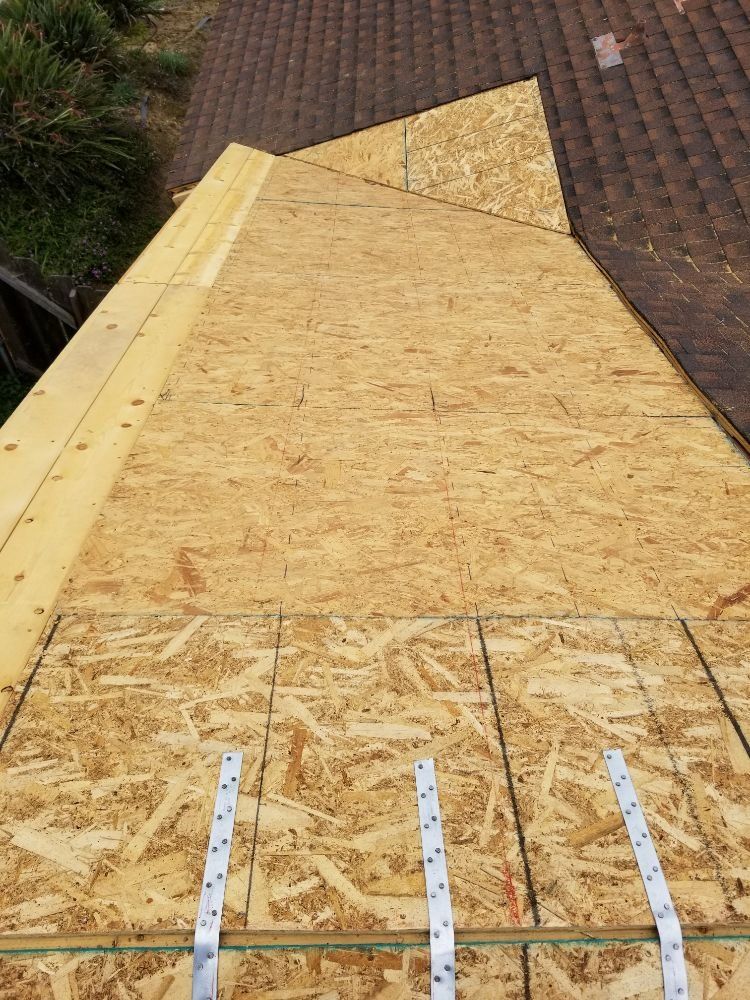 A roof is being built with plywood and shingles.
