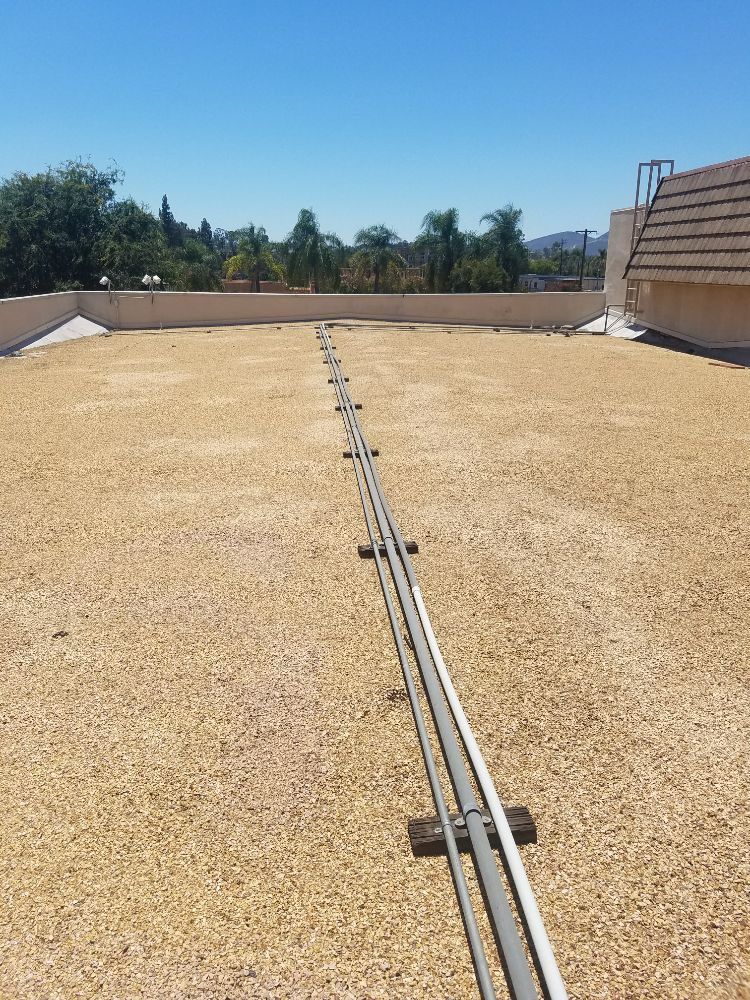 A roof with a lot of wires on it and a blue sky in the background.