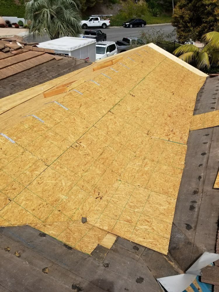 The roof of a house is being remodeled and covered in plywood.
