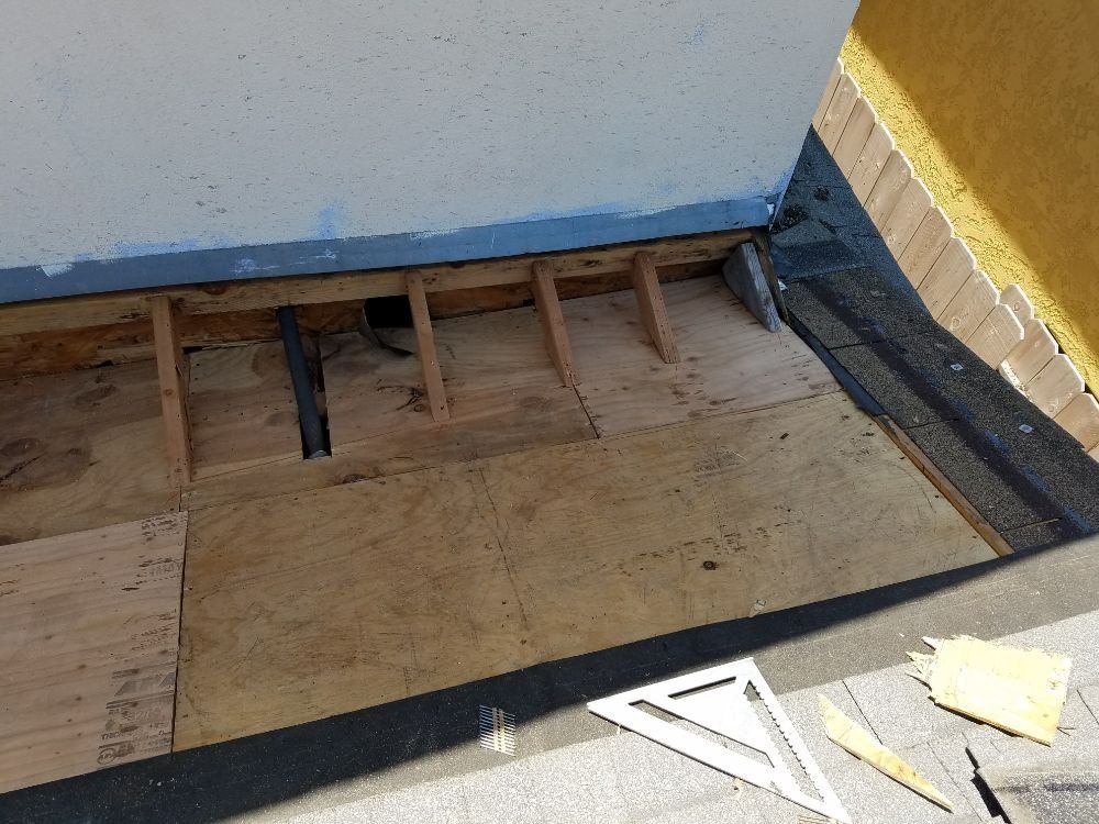 A piece of plywood is sitting on the ground next to a triangle.