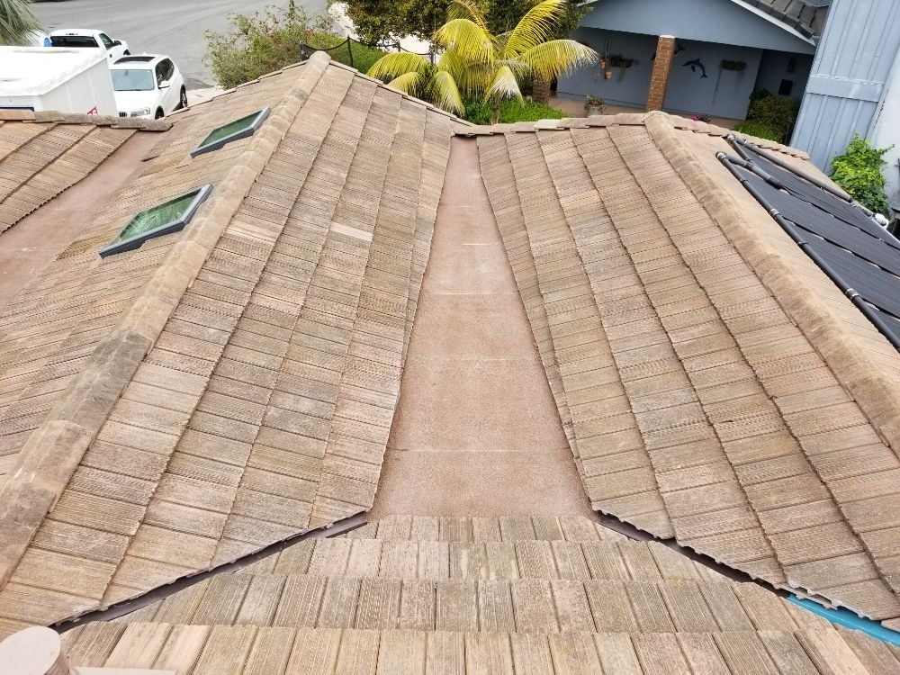 An aerial view of a roof with wooden tiles and skylights.