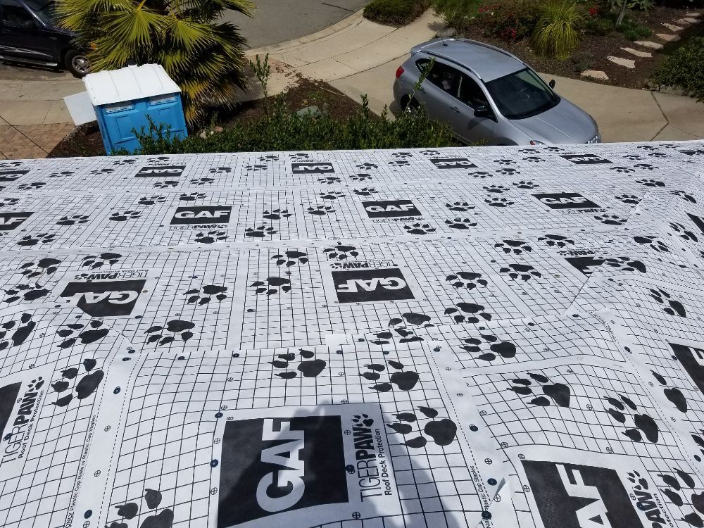 An aerial view of a roof with a car parked in the background.