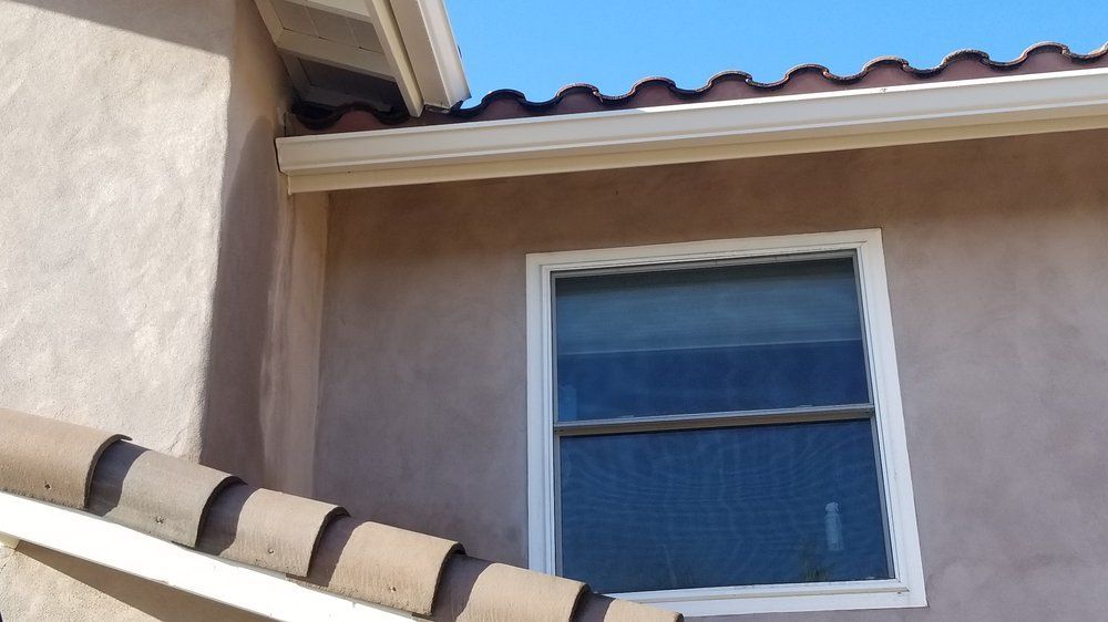 A window on the side of a building with a tiled roof