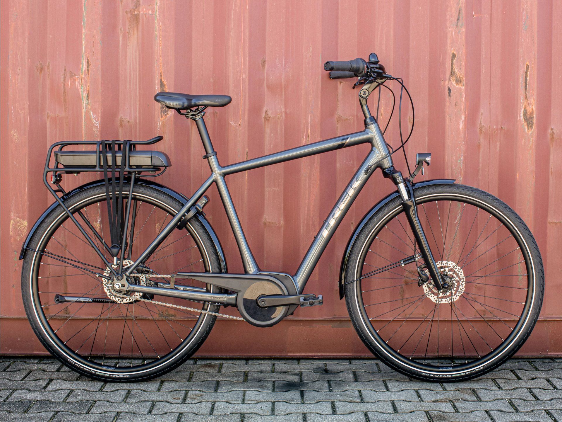 a trek bicycle is parked in front of a red wall