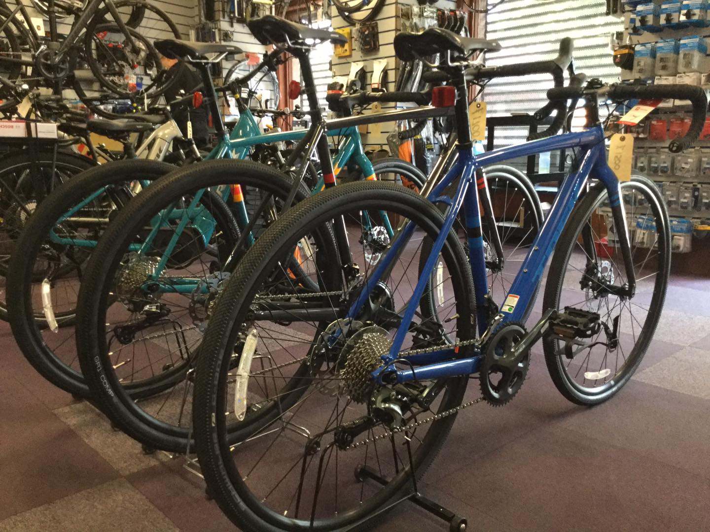 two bicycles are parked in front of a bar that has a bottle of beer on it