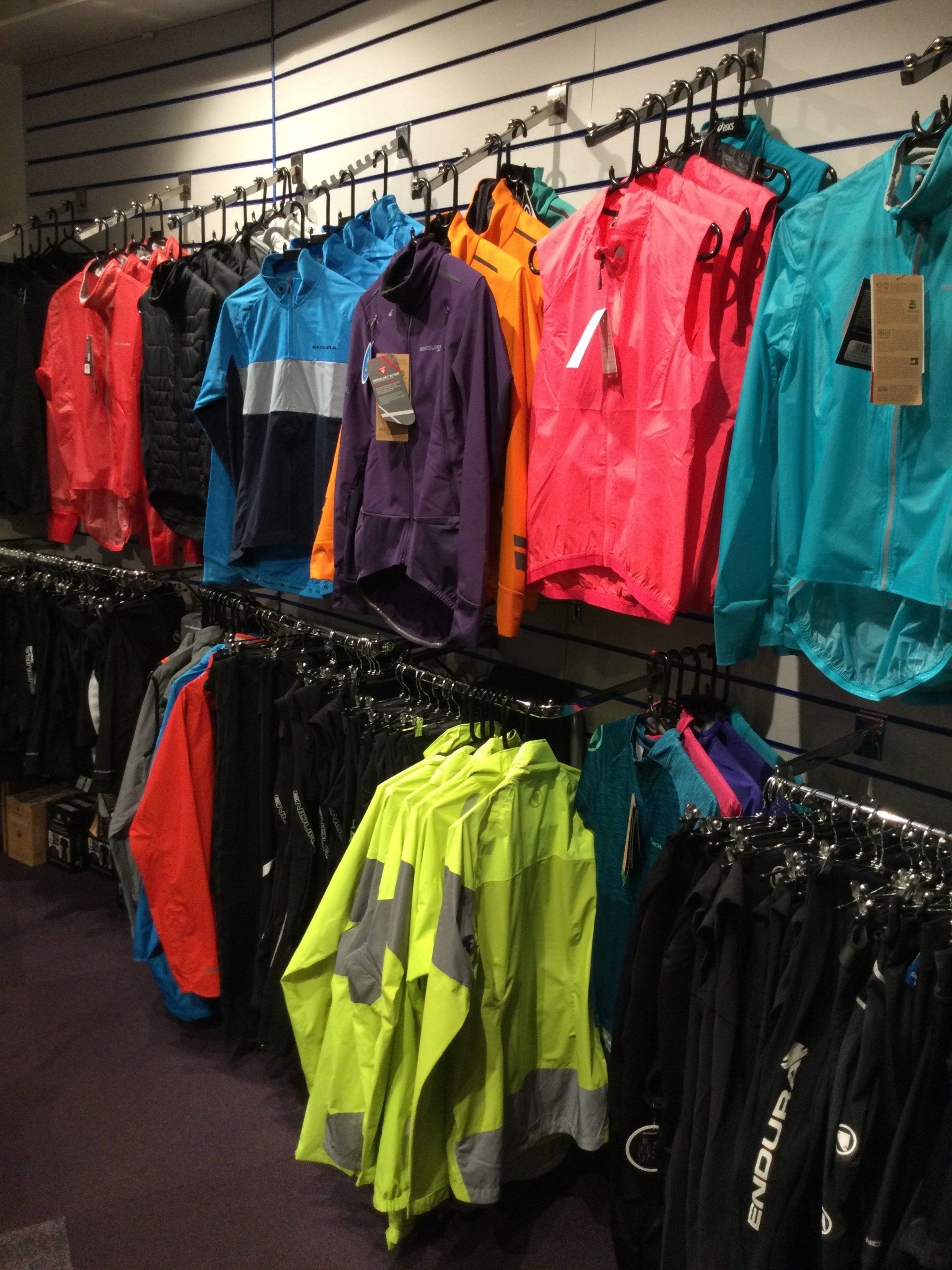 a bunch of jackets hanging on a rack with one that says enduro on it
