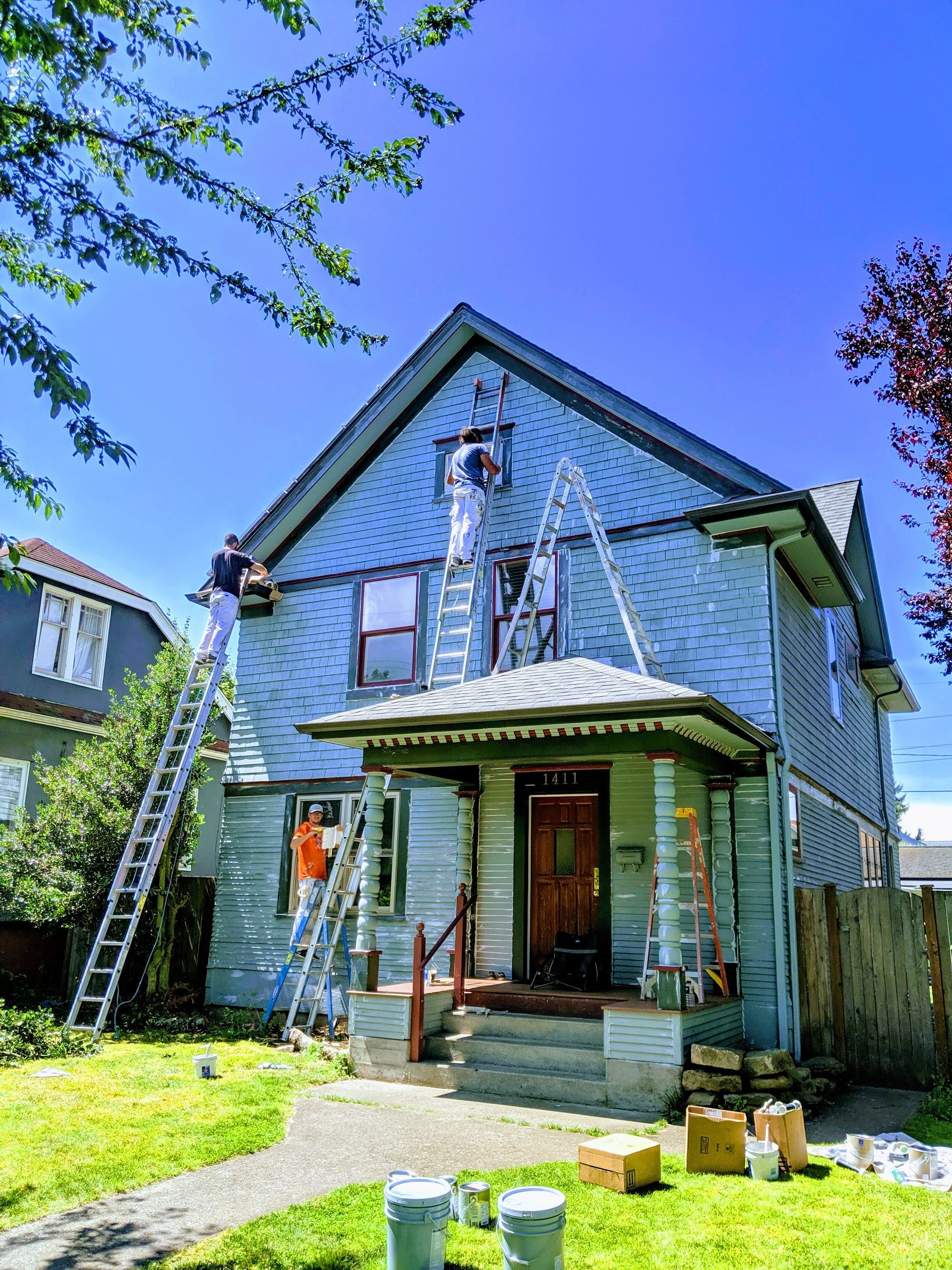 A truck is parked in front of a house being painted.