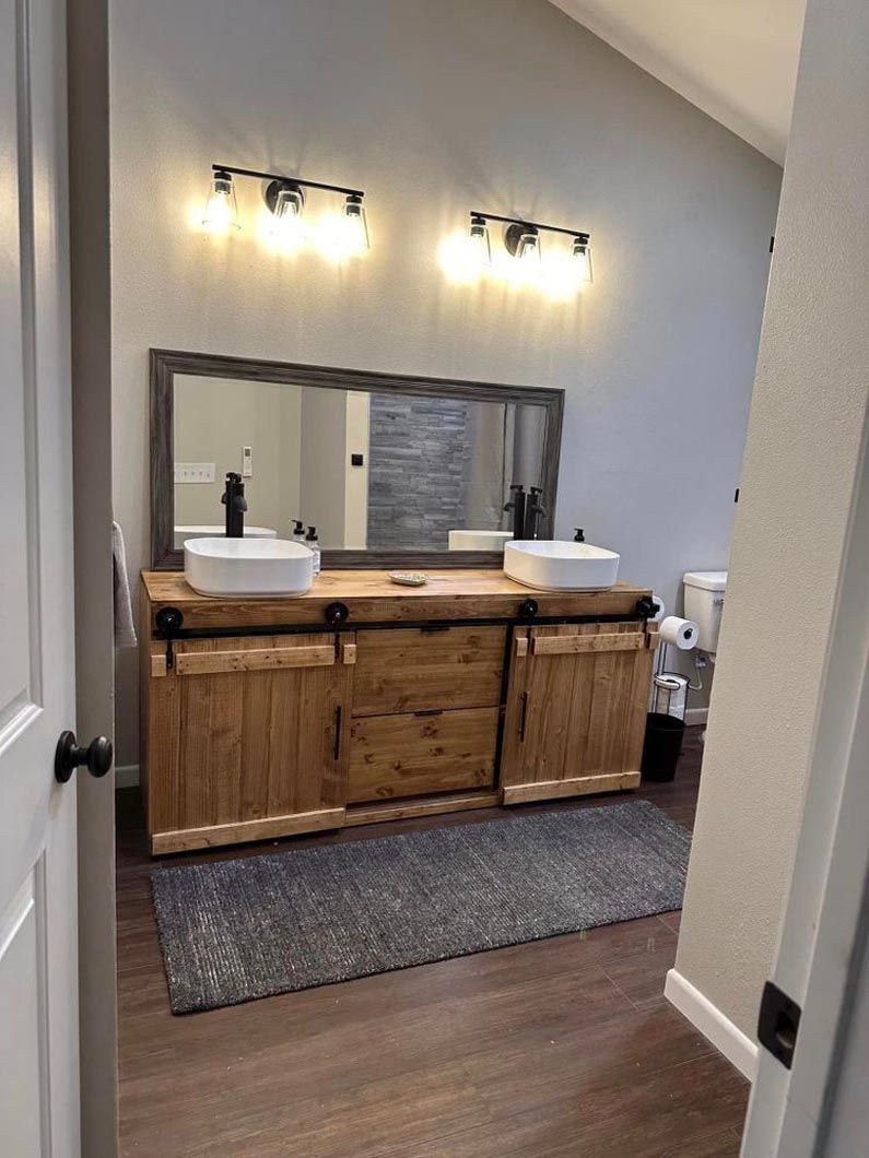 A bathroom with two sinks and a large mirror.