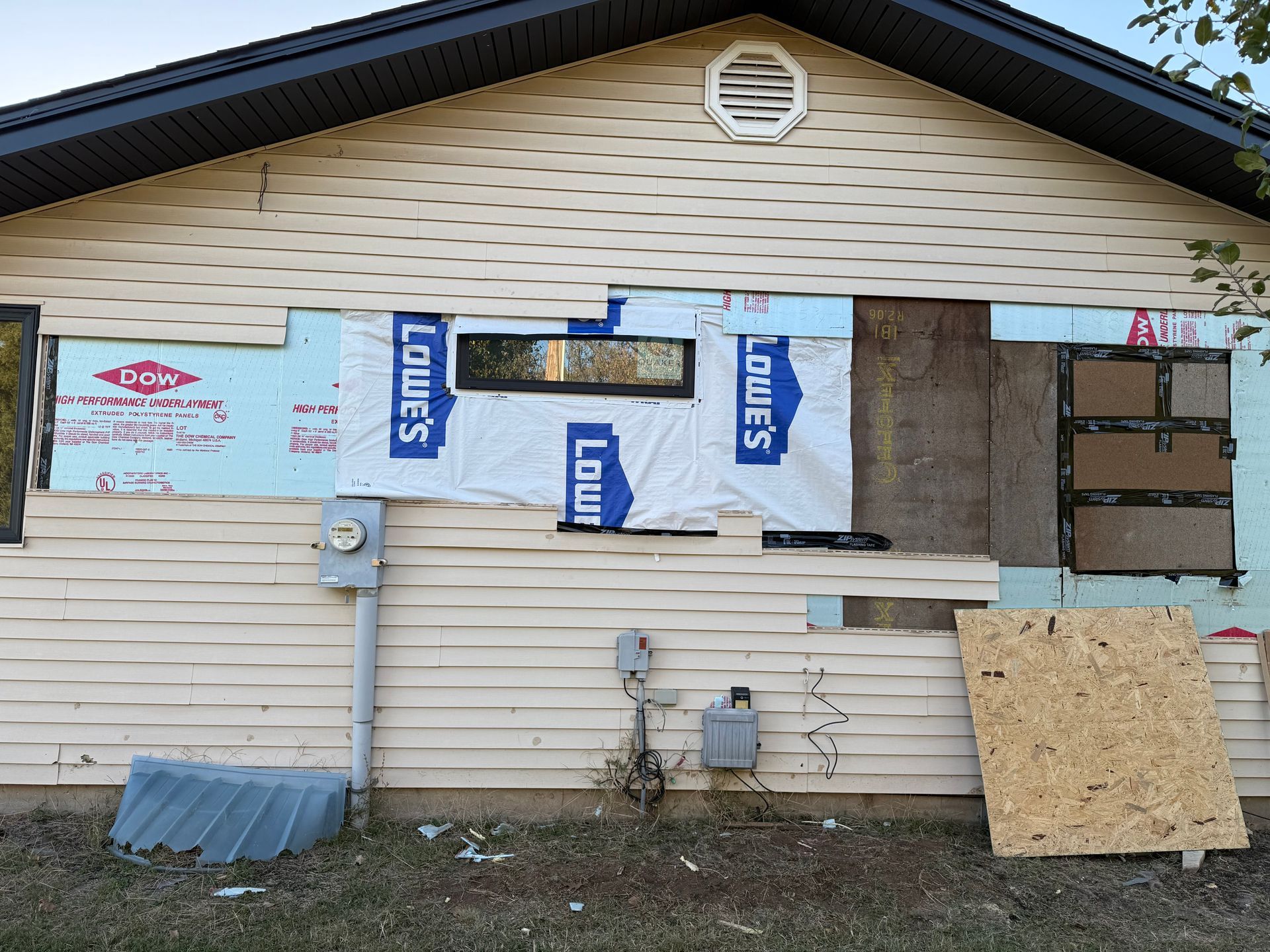 Exterior of a house with damaged siding.  
