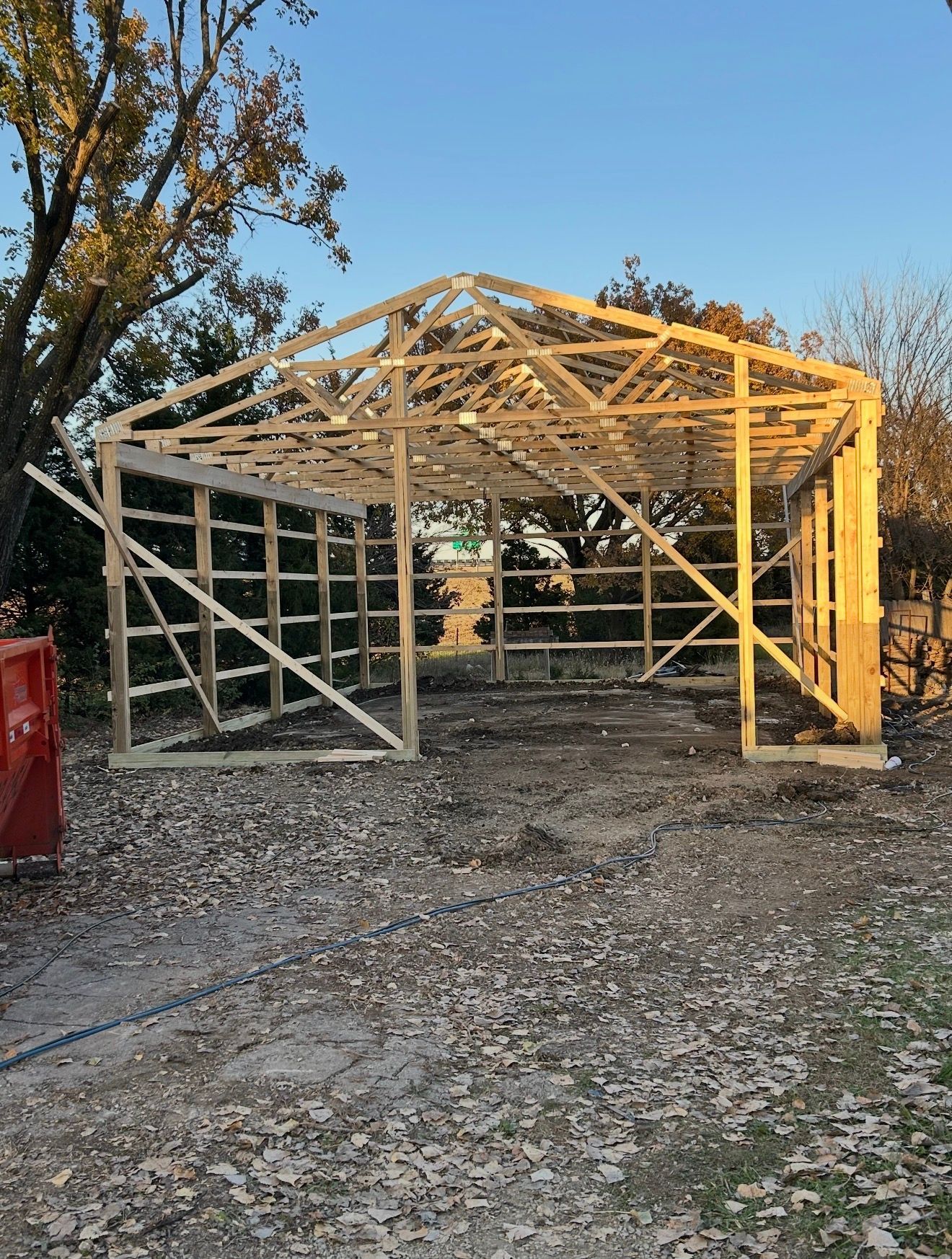 Wooden frame of a partially built garage, set outdoors.