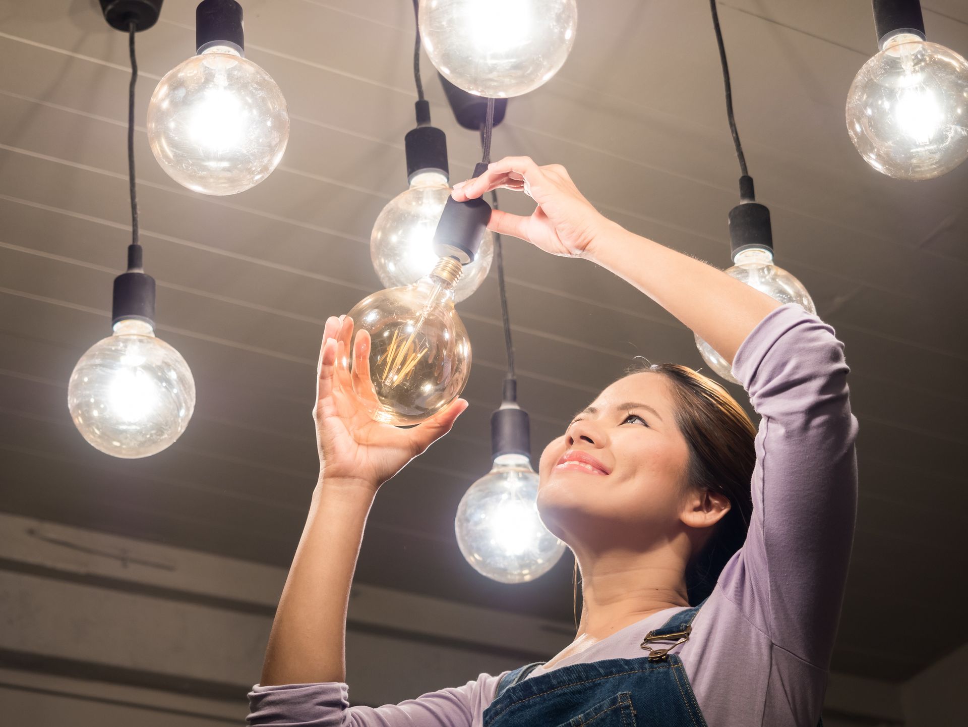 Homeowner evaluating light bulbs for smart electrical installations and lighting improvements.