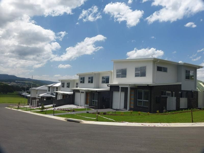 A Row of Houses on a Sunny Day With Mountains in the Background — Sheps Roofing Service Pty Ltd In Wollongong, NSW