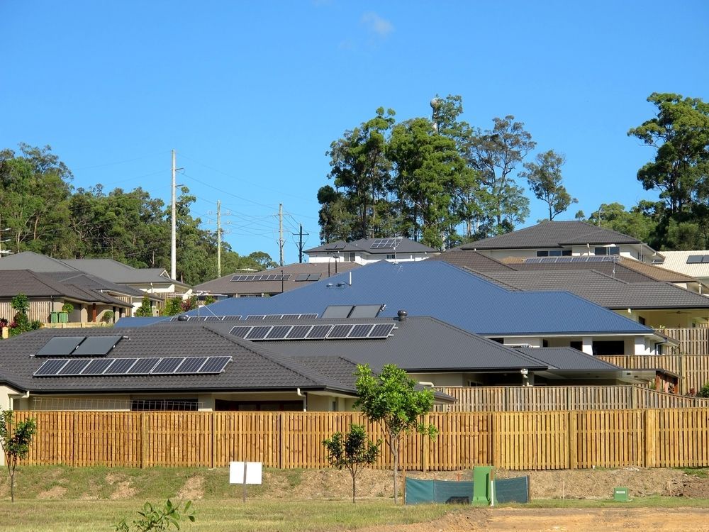 A Row of Houses With Solar Panels on the Roofs — Sheps Roofing Service Pty Ltd In Wollongong, NSW