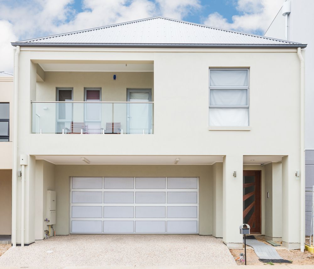 A White House With a White Garage Door and a Balcony — Sheps Roofing Service Pty Ltd In Kiama, NSW
