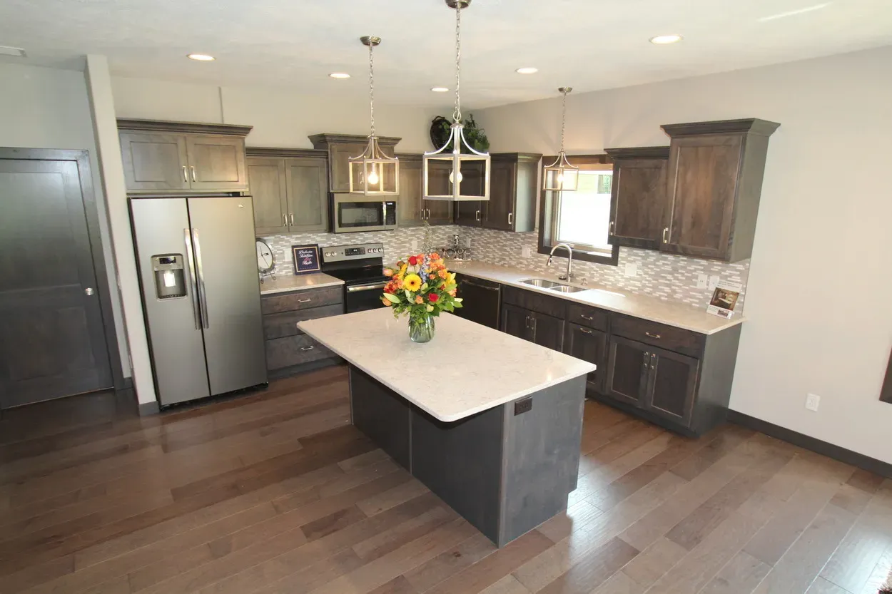 Kitchen with dark wood cabinets, stainless steel appliances, and a gray island with a white countertop.