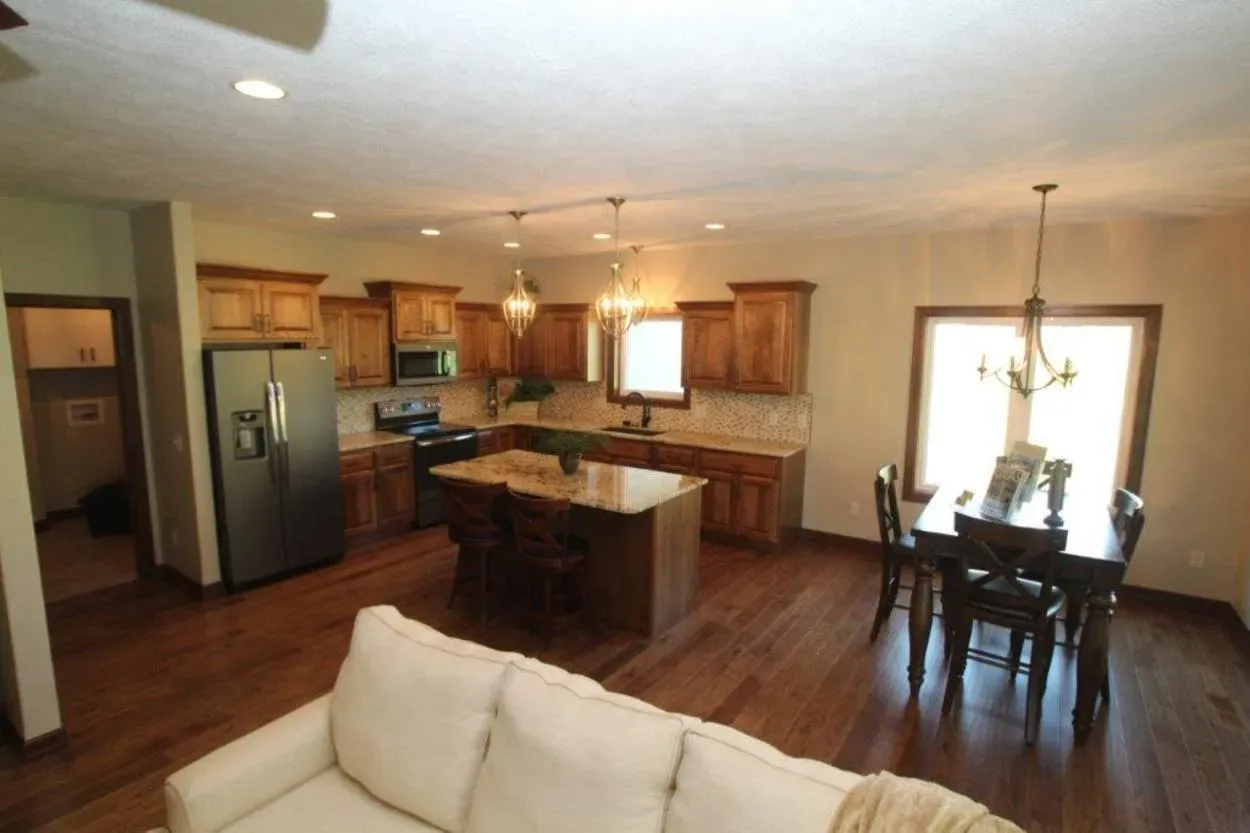 Open-concept kitchen and dining area with wood cabinets.