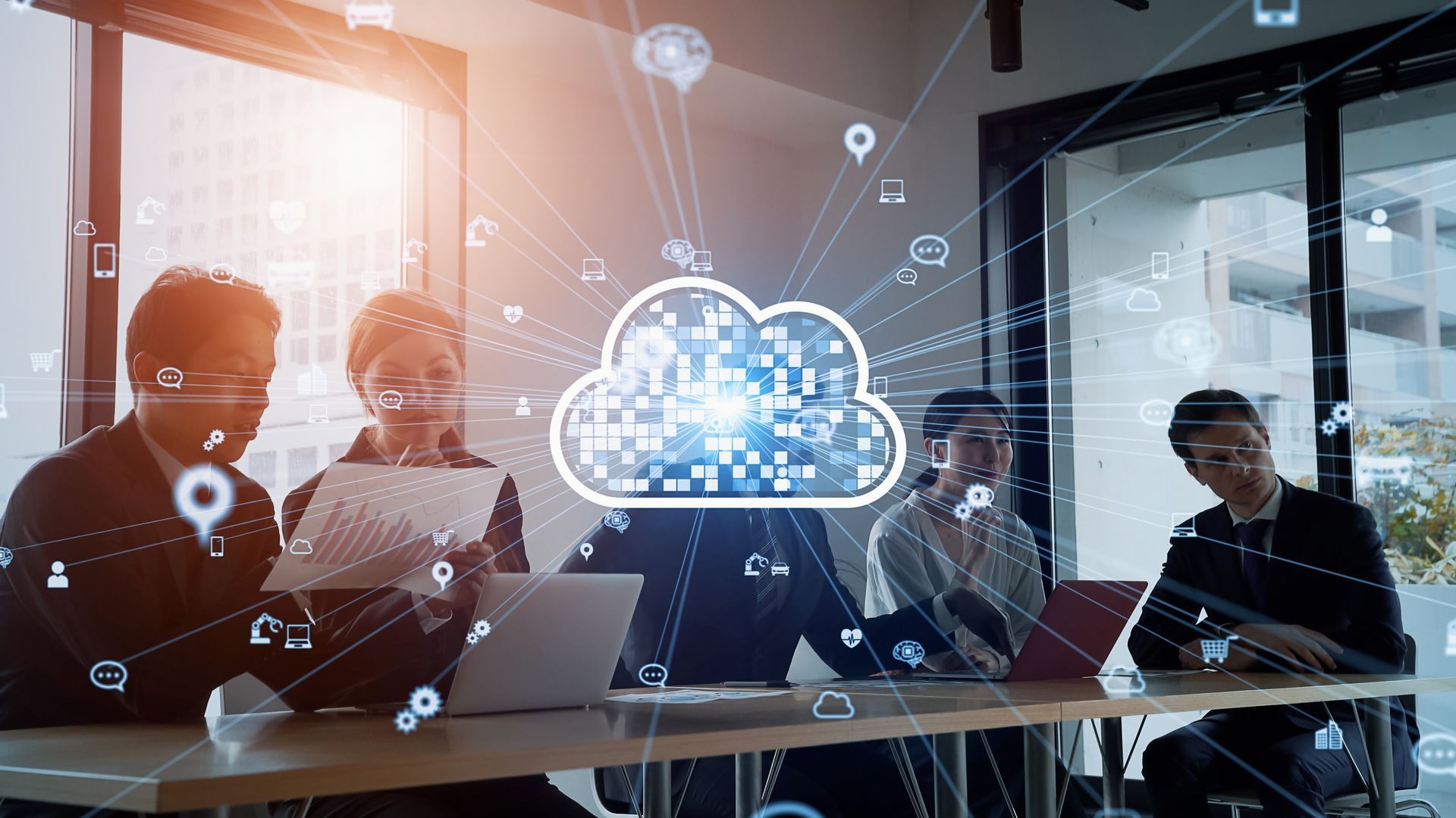 Business people in a meeting around a table, cloud computing concept.