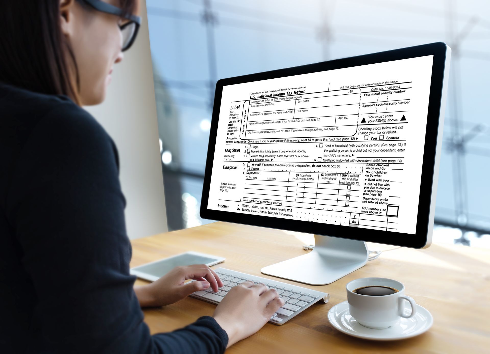 a woman is using a computer to fill out a u.s. individual income tax return