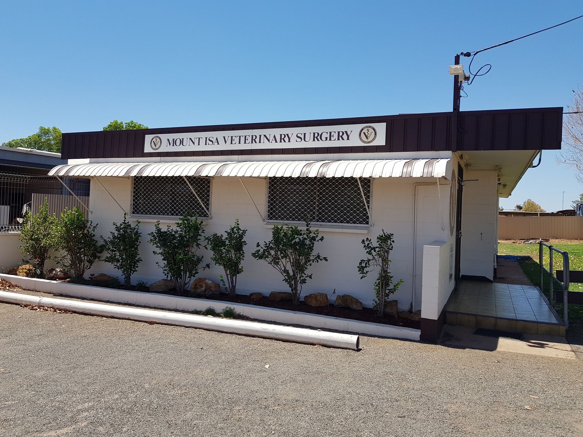 White Building With A Brown Roof, The Sign Reads