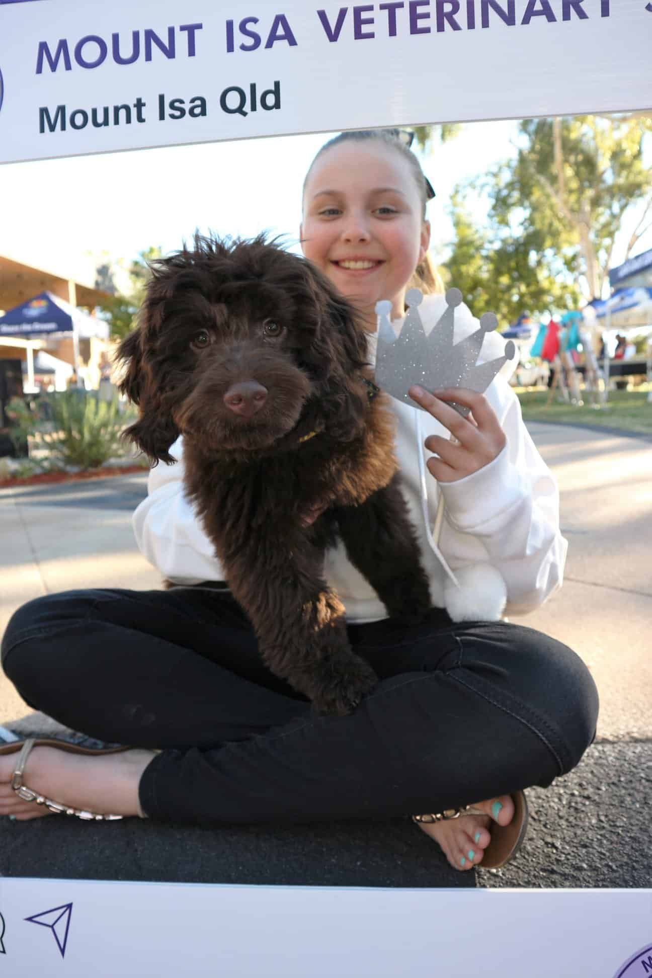 Girl Sitting, Holding Brown Puppy, Smiling — Mount Isa Veterinary Surgery In Ryan, QLD