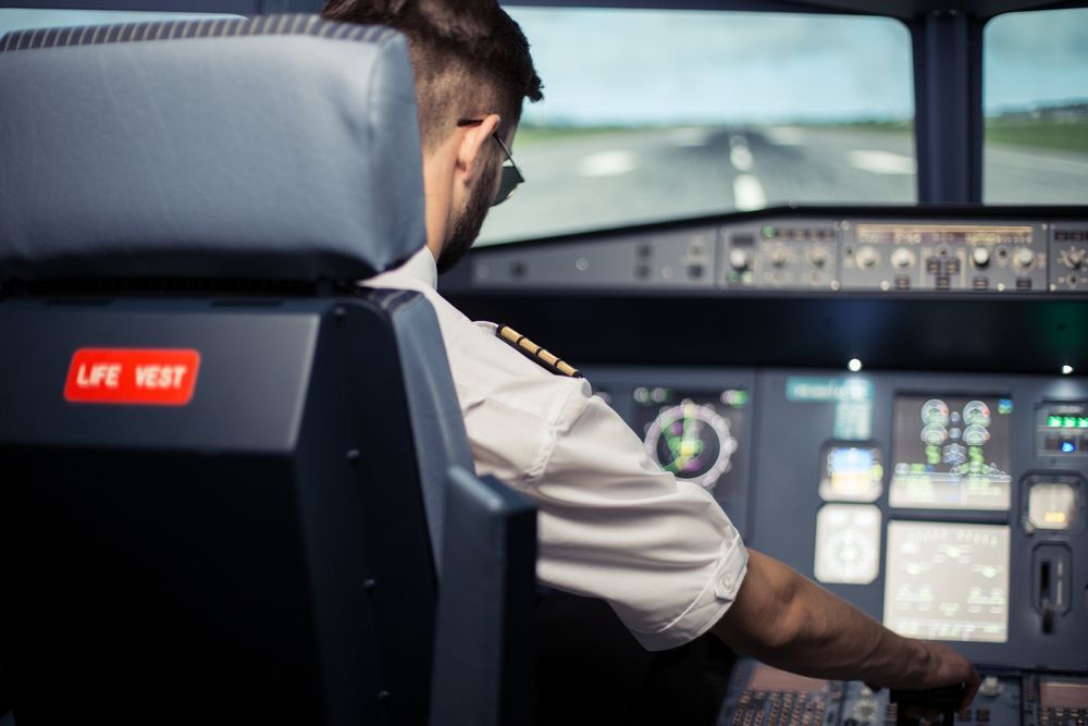 Pilot controlling an airplane by electronic panel.