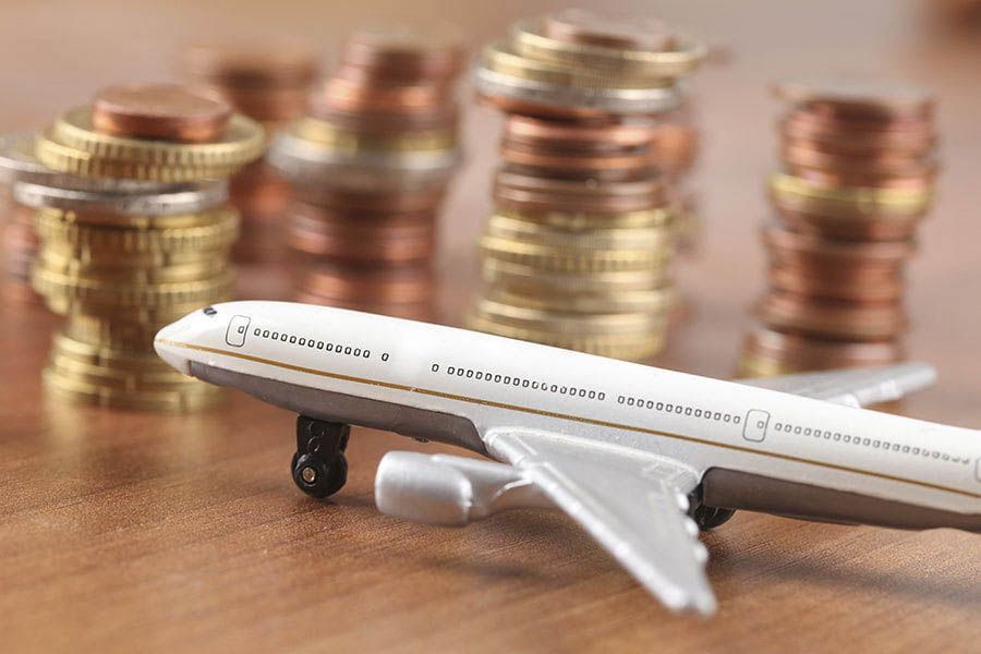 a model airplane with stacks of coins in the background indicating an airline pilot salary