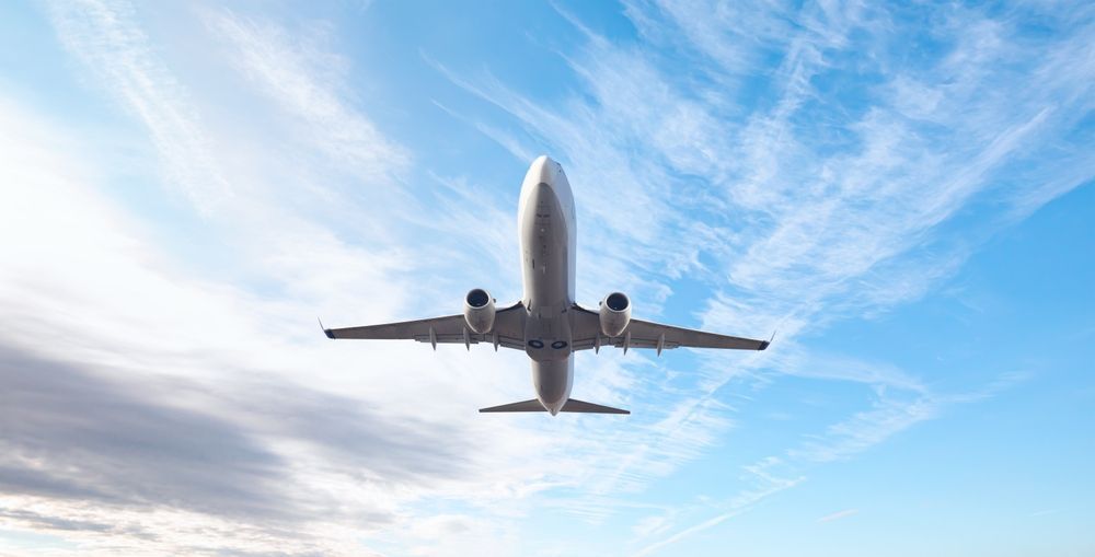 image of a passenger airplane flying in a fairly clear sky