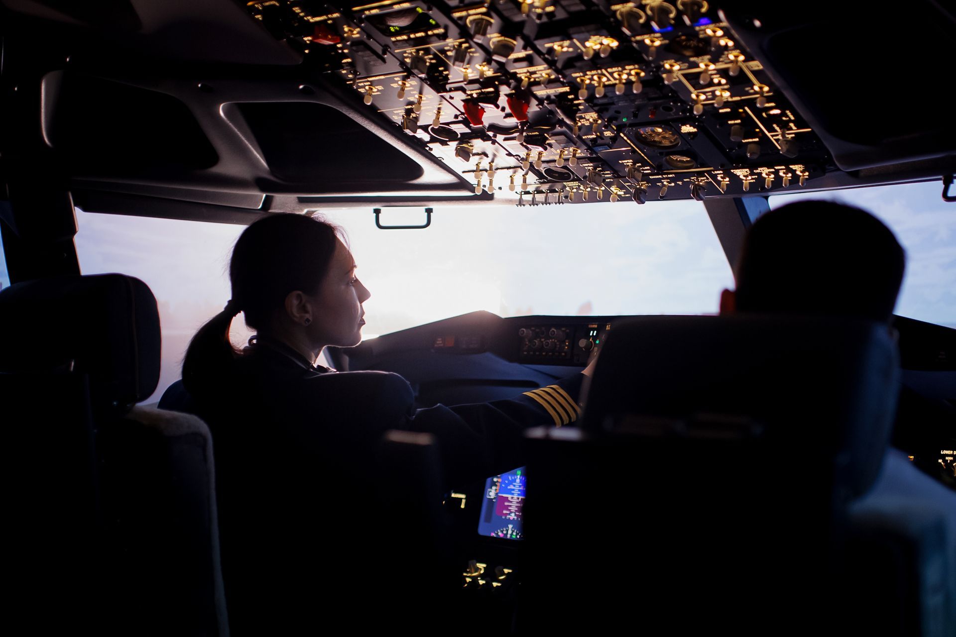 A man and a woman are sitting in the cockpit of an airplane. they are paid a commercial airline pilot's salary