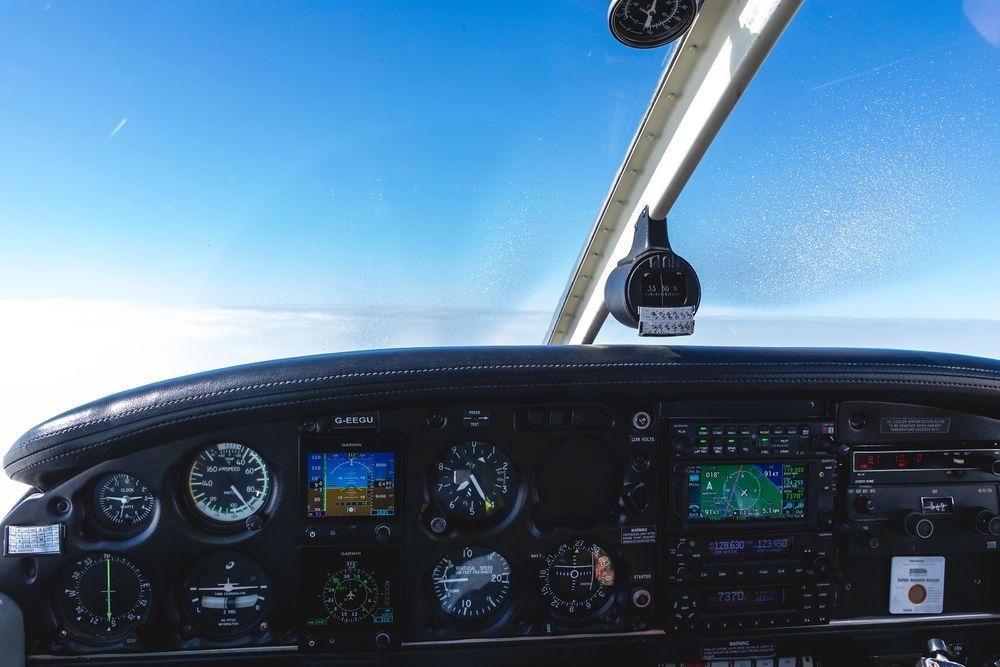 A cockpit of an airplane with a blue sky in the background