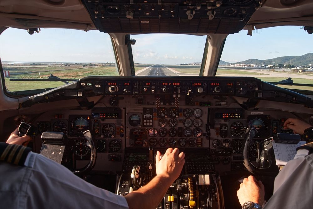 Two pilots are sitting in the cockpit of an airplane