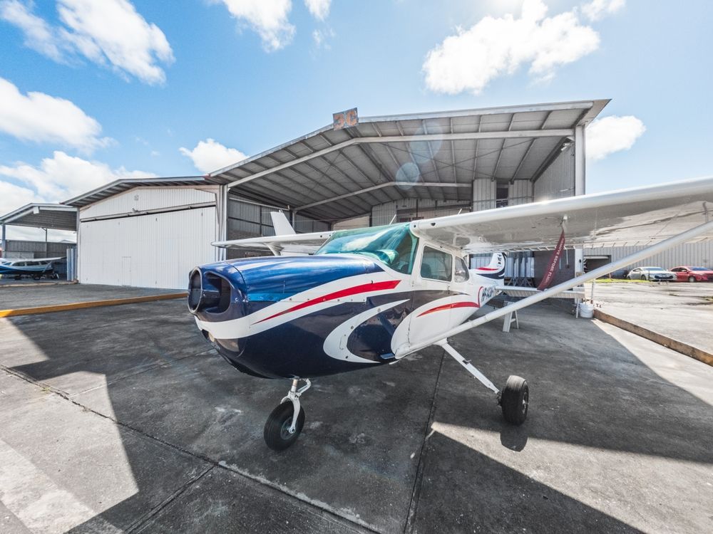 A small plane is parked in front of a hangar.