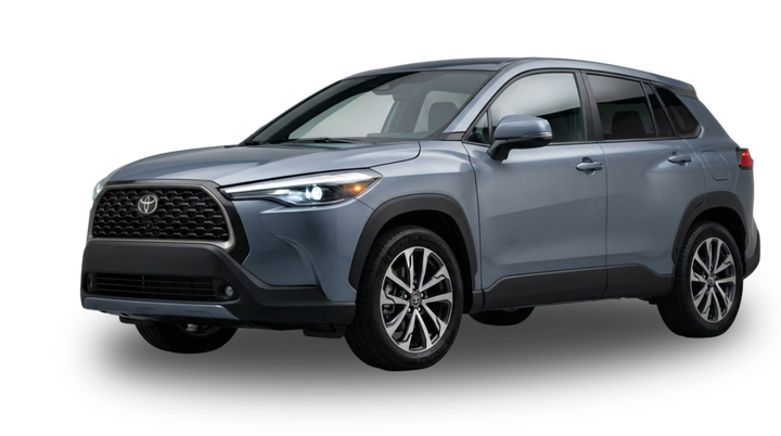 A grey Toyota Corolla Cross SUV viewed from the front three-quarter angle against a plain white background.