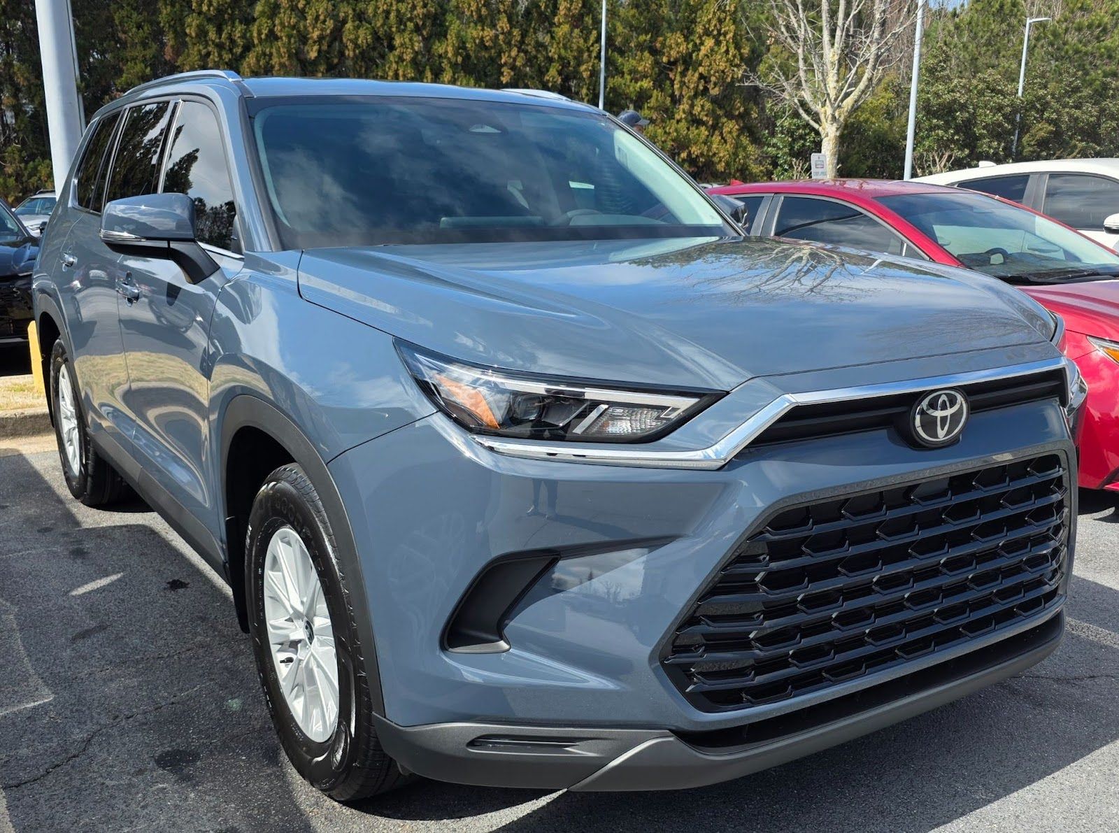 A dark blue Mercedes-Benz C-Class sedan parked on a concrete driveway in front of a white garage door.