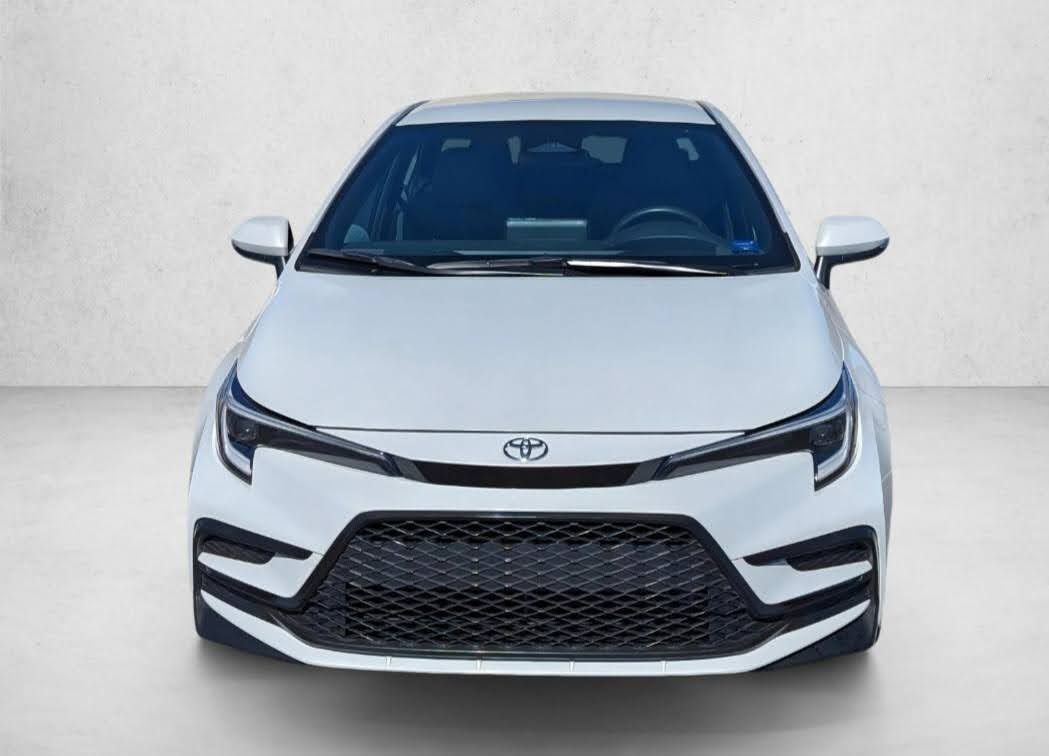 A white Toyota Corolla sedan viewed from the front against a neutral background.