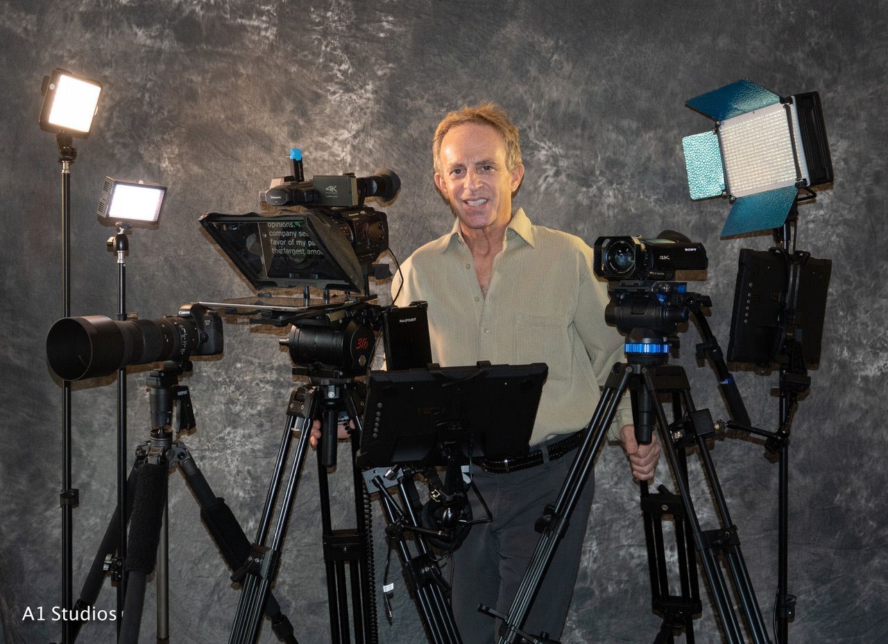 Cliff is standing in front of a bunch of cameras and lights