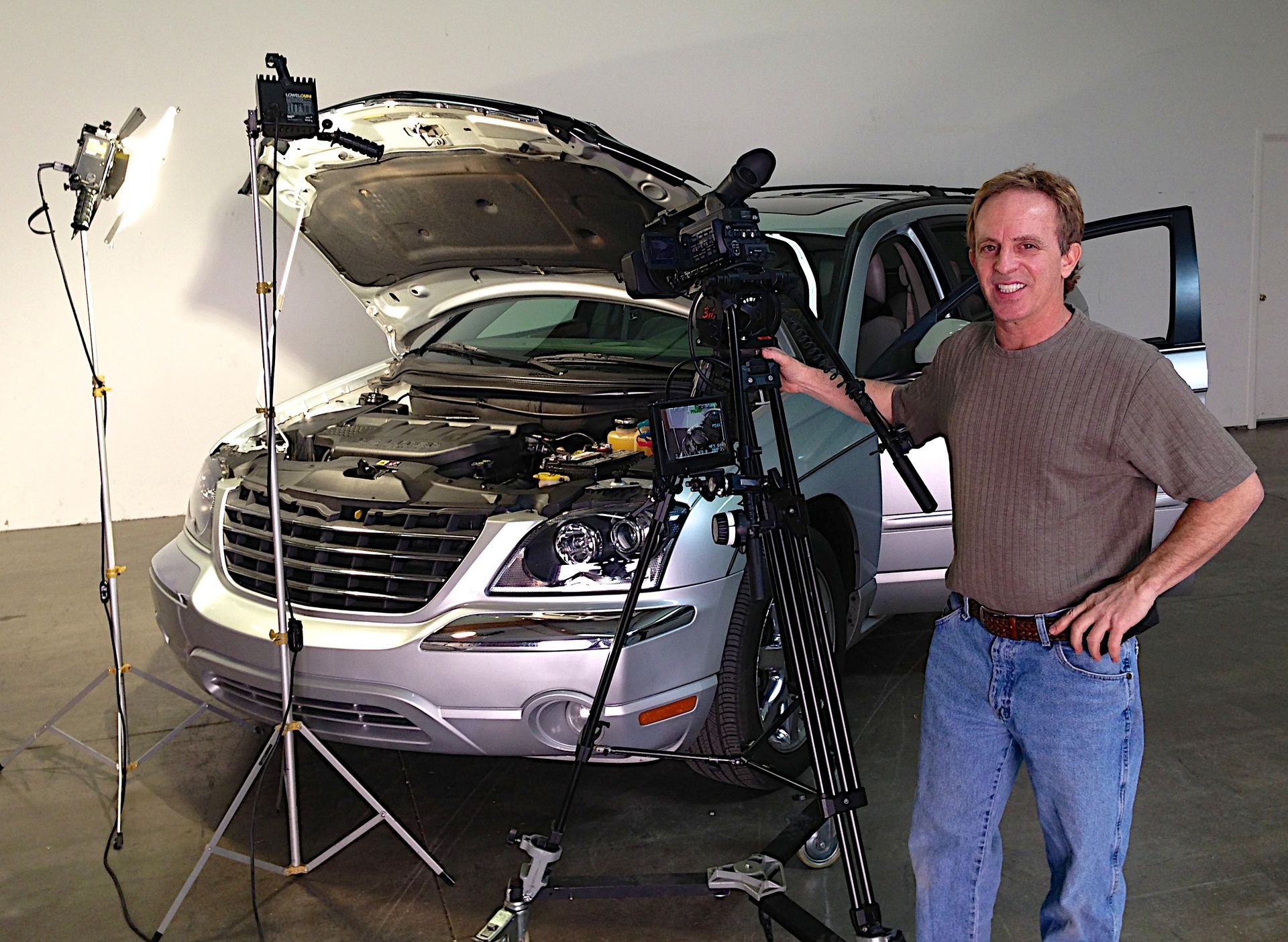 Cliff is standing in front of a silver car with the hood open