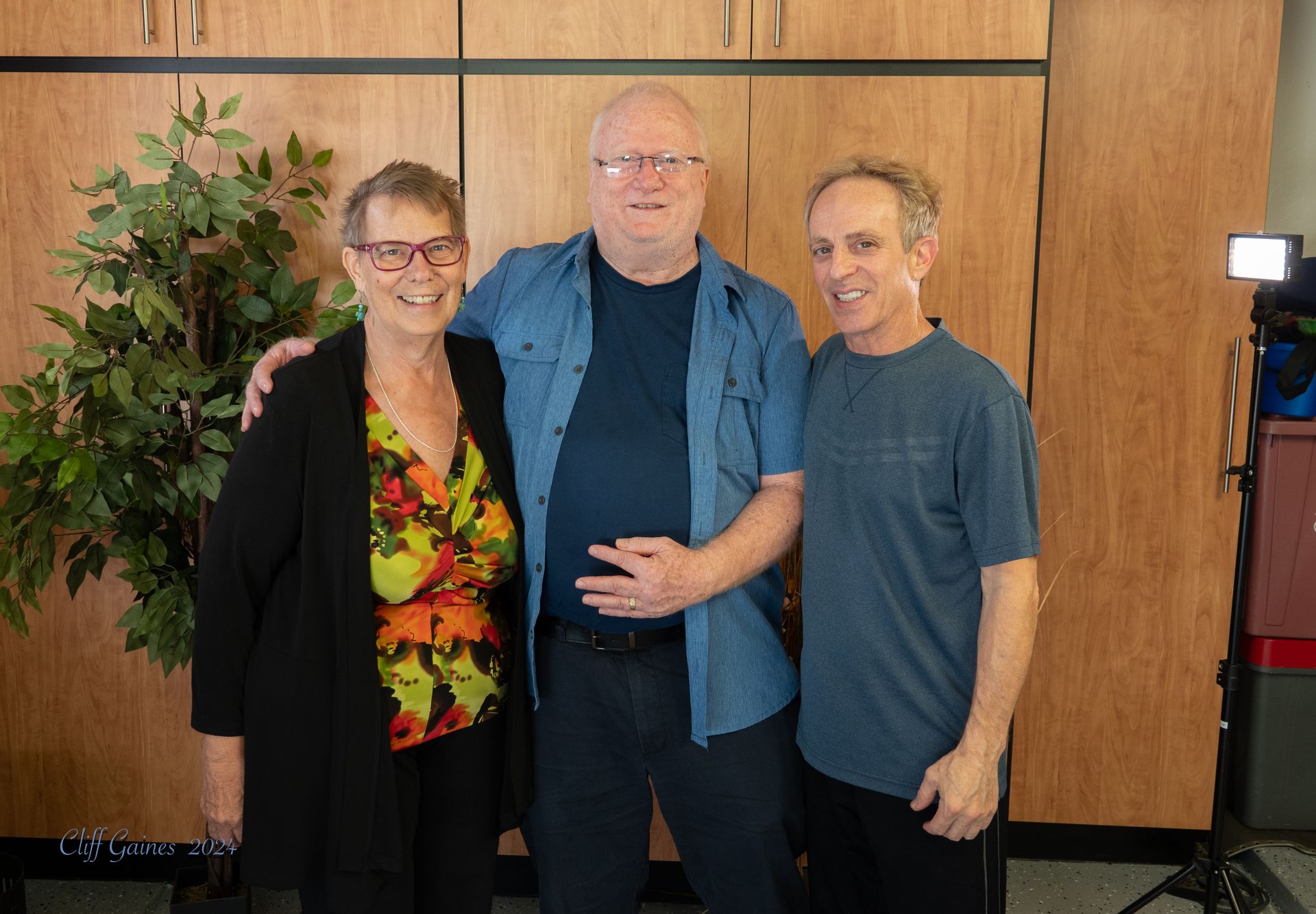 Cliff and the senior couple are posing for a picture together.