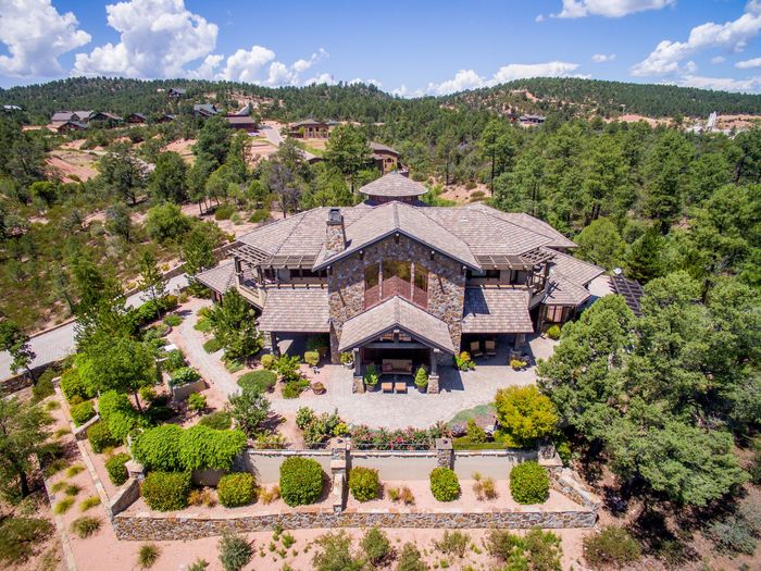 An aerial view of a large house surrounded by trees and bushes.