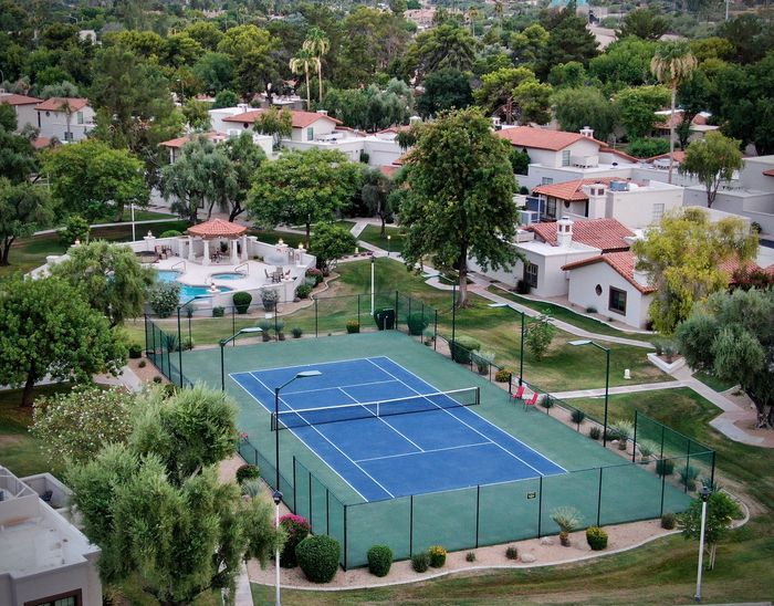 An aerial view of a tennis court surrounded by trees